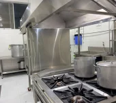 Cocinas industriales con ollas en la zona de preparación de alimentos