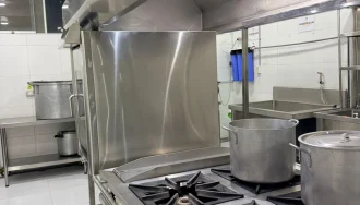 Cocinas industriales con ollas en la zona de preparación de alimentos