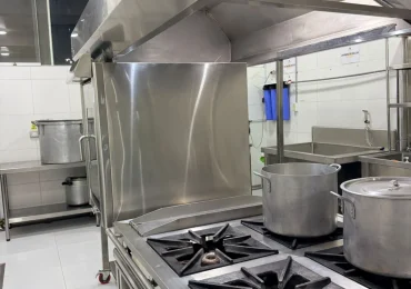 Cocinas industriales con ollas en la zona de preparación de alimentos